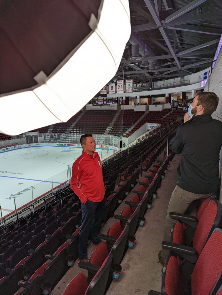 camera person recording a man in a hockey arena