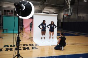 Volleyball players standing in front of a white backdrop on video set