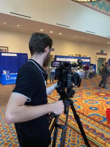 Man taking video of exhibition hall lobby