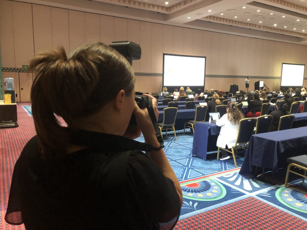 Woman with camera taking picture in crowded room