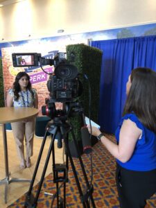 Woman being interviewed in front of camera and interviewer