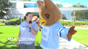 A girl and mascot stand together