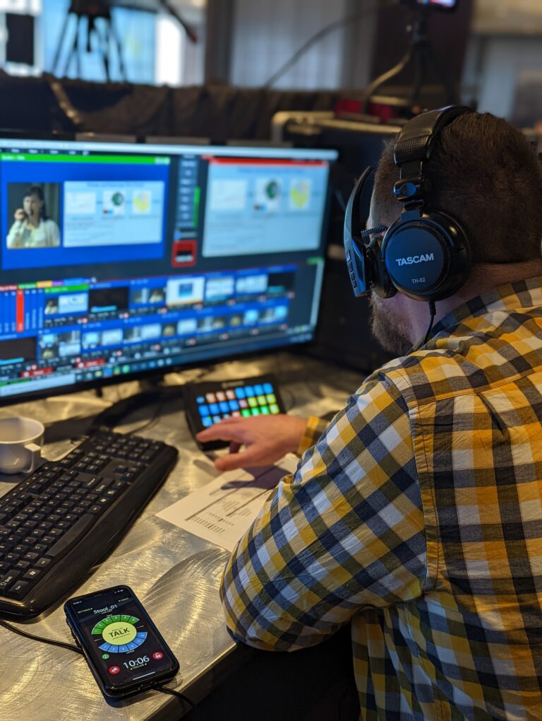Man sitting in front of live streaming equipment streaming a hybrid event
