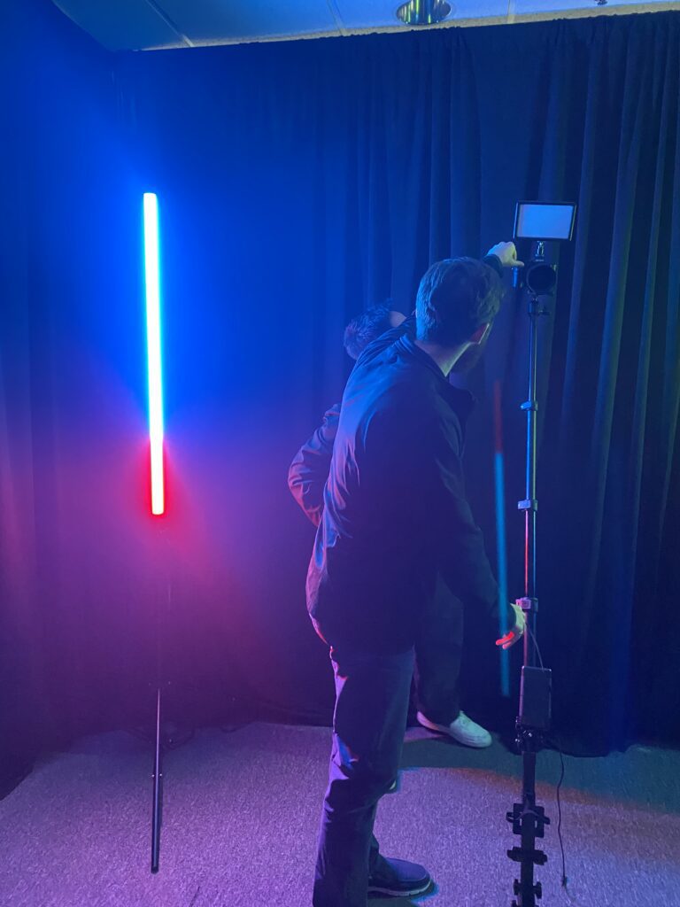 Two men adjusting a camera on a 360 video booth