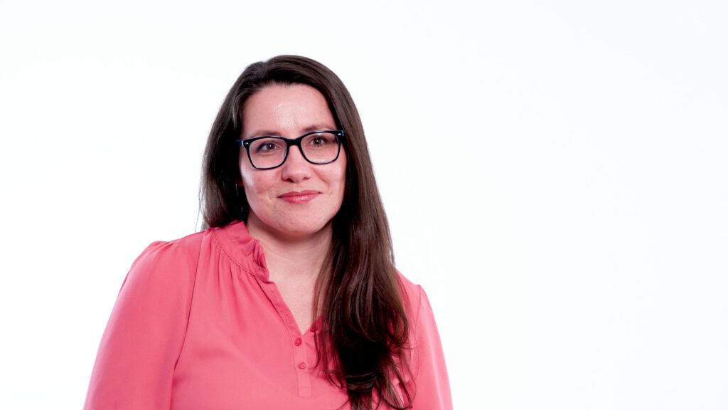 Zuzana sitting in front of a white backdrop