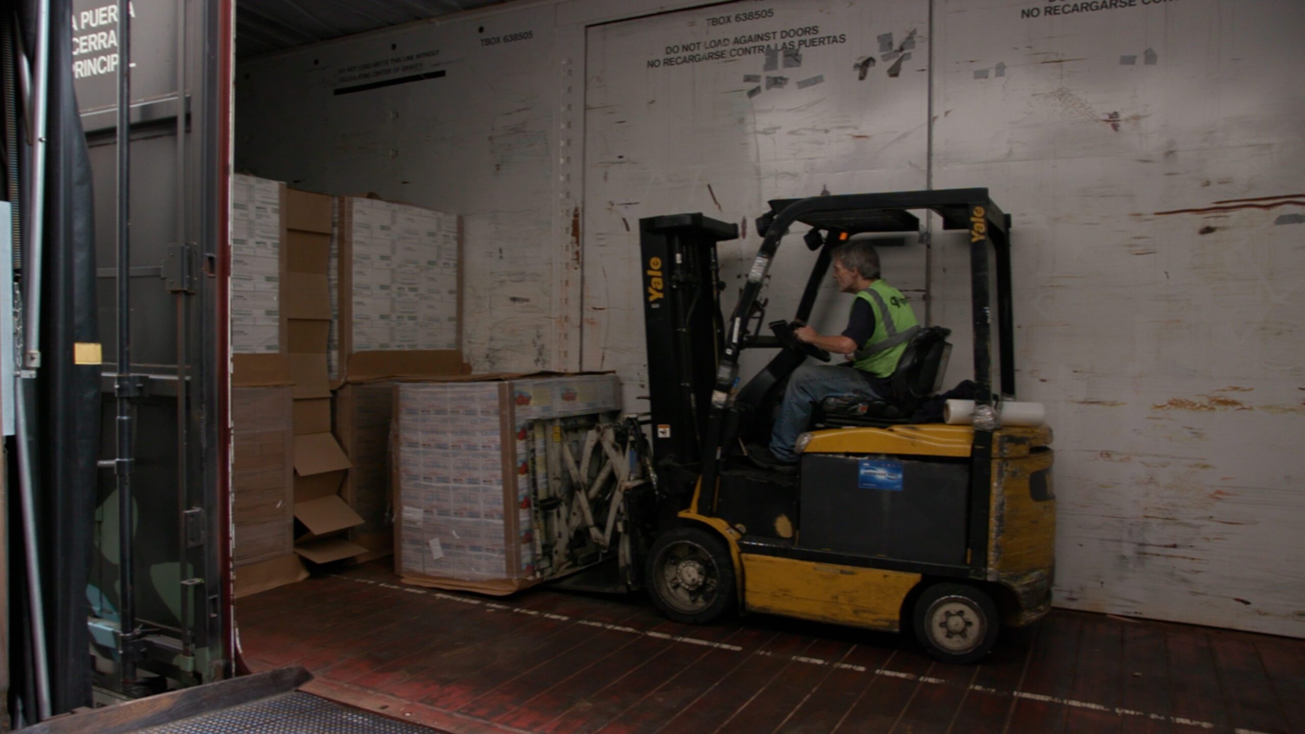 Man driving a forklift and carrying boxes