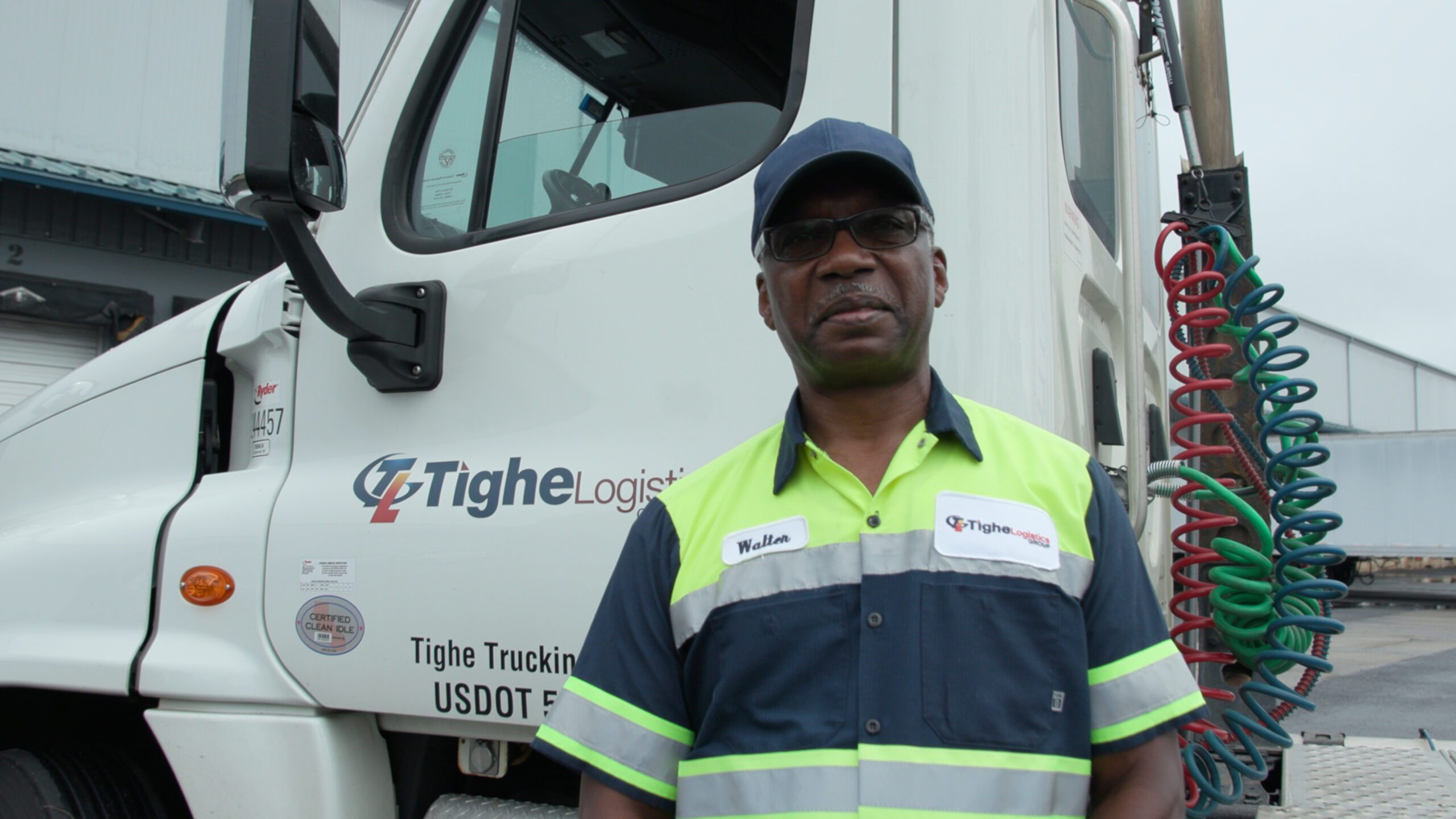 Tighe Logistics employee standing in front of a truck