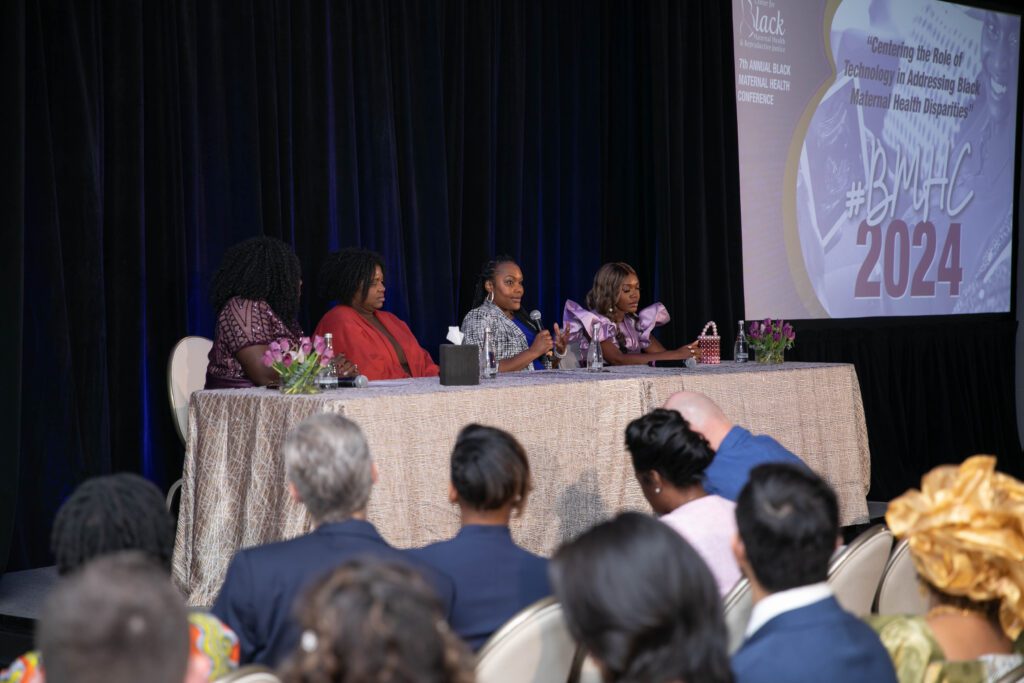 Women sitting on panel at event