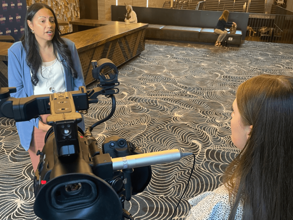 Woman interviewing another woman at an event