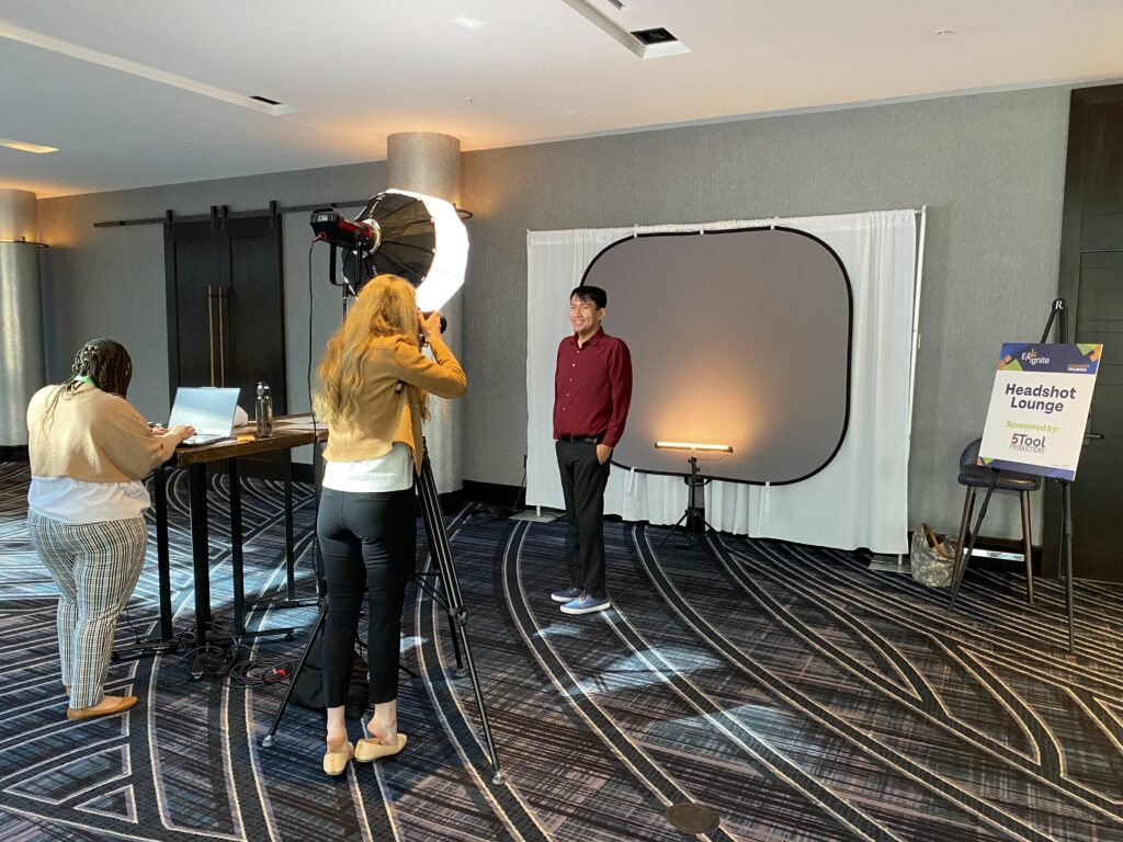 Woman taking photo of man at headshot booth