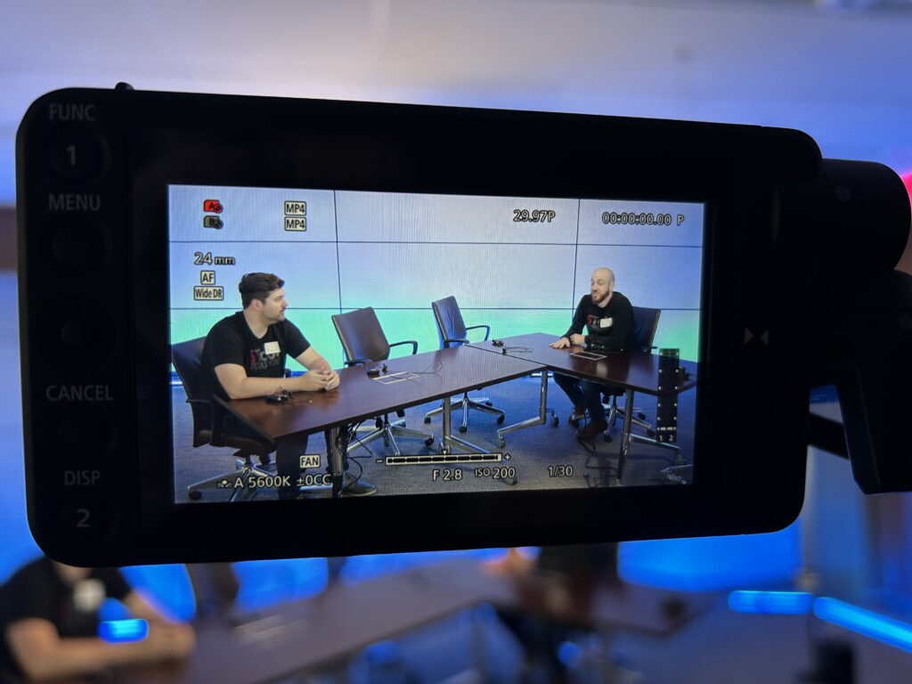 Two people sitting at a table through a viewfinder