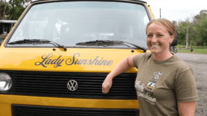 Woman standing next to a truck that says "Lady Sunshine"